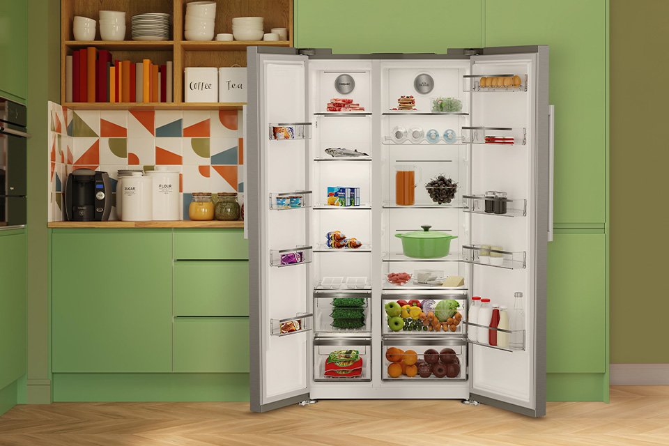 A Hotpoint white double door fridge freezer built into modern green kitchen cabinets.