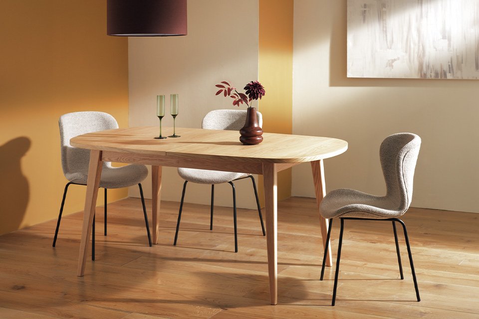 A Habitat extending 6-8 seater dining table with rounded edges in natural wood colour.