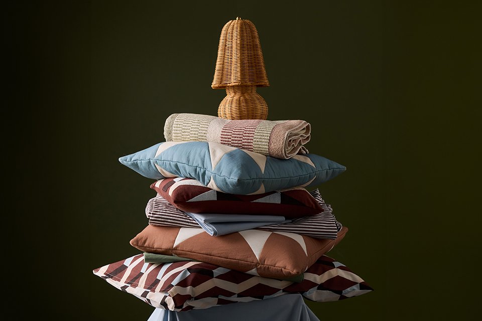 Blue and brown patterned cushions and pillows placed on top of each other.