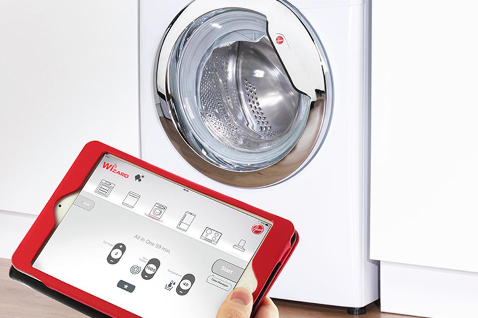 Person using tablet to control Smart washing machine.