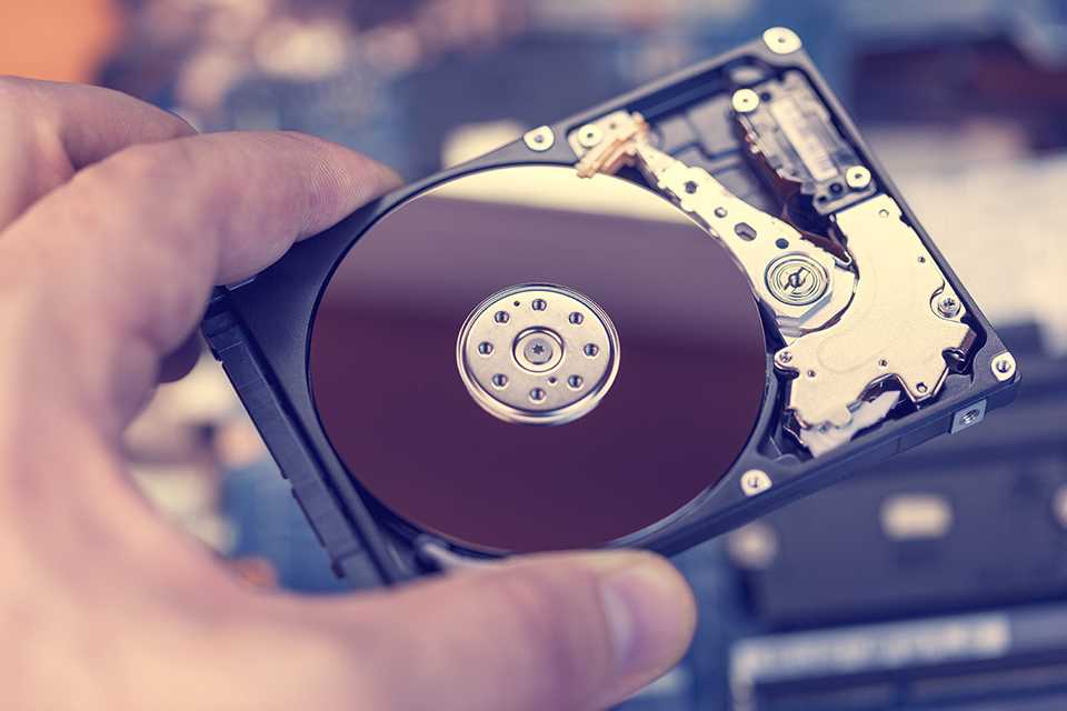 Person holding a hard disk drive.