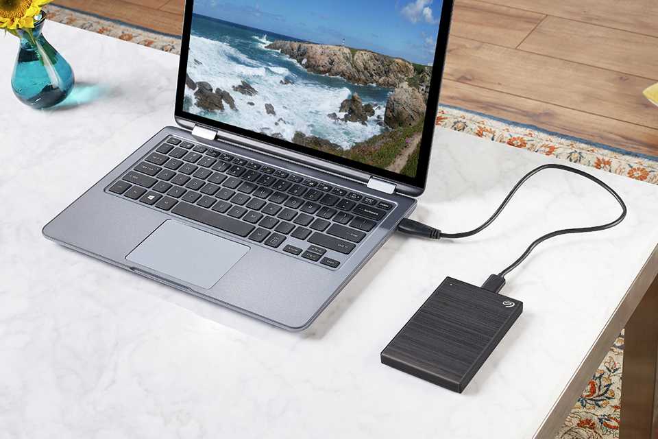 Portable hard drive plugged into a laptop.