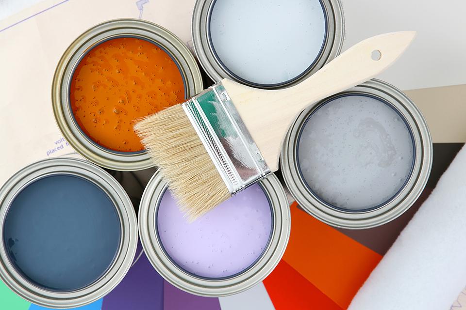 Colourful paint tins with a paintbrush.