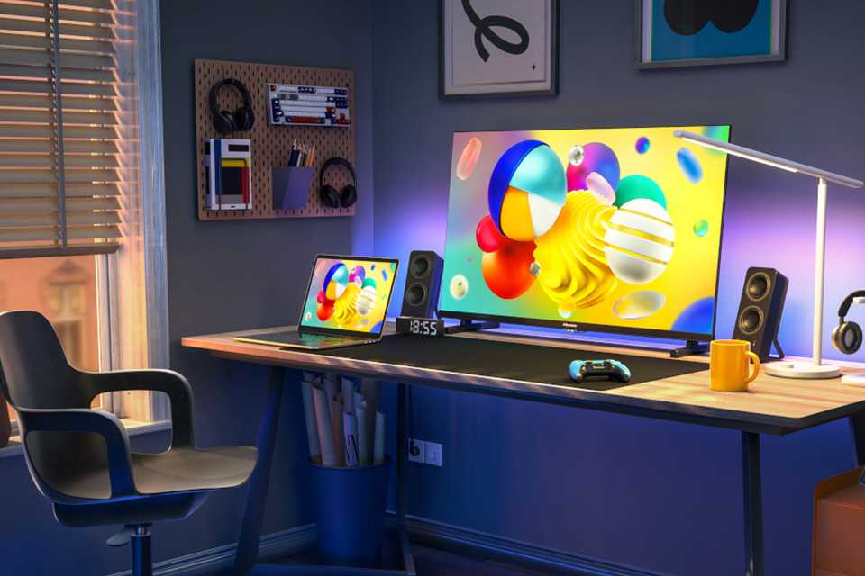 A Hisense E7H QLED 4K HDR TV stood on a TV unit in a well-lit living room.