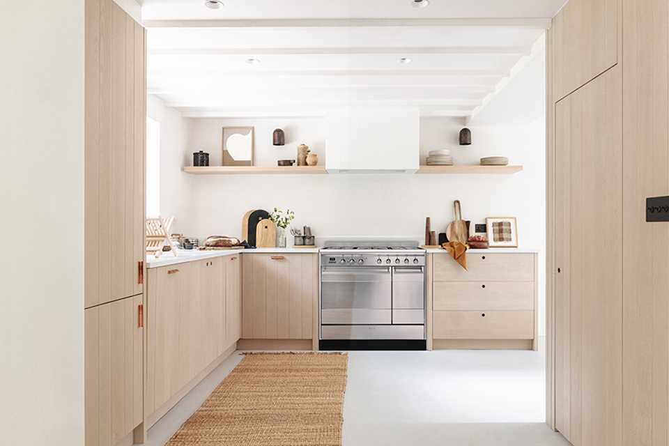 A neutral Scandivanian style kitchen with Smeg concert range cooker in stainless steel.