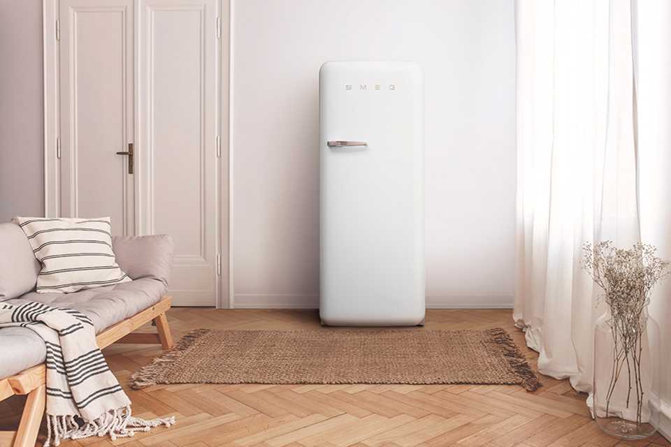 Neutral coloured space with white Smeg fridge.