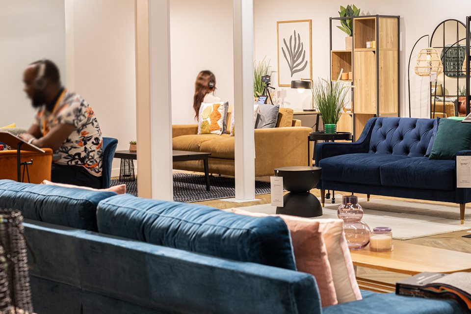 Woman phone shopping in living room discovering more ways to pay at Argos.