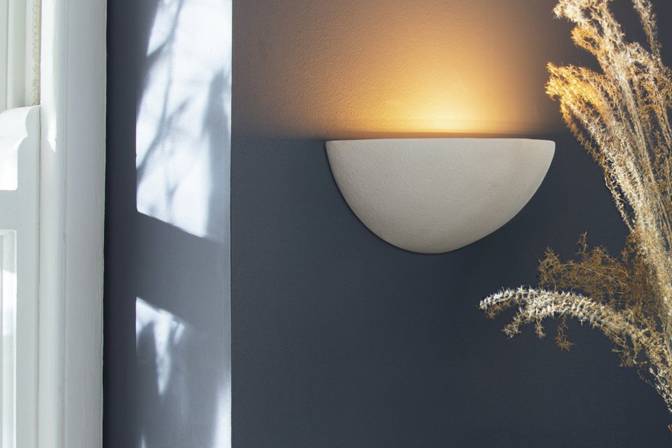 Argos Home Mars ceramic wall light in white colour on a dark grey wall.