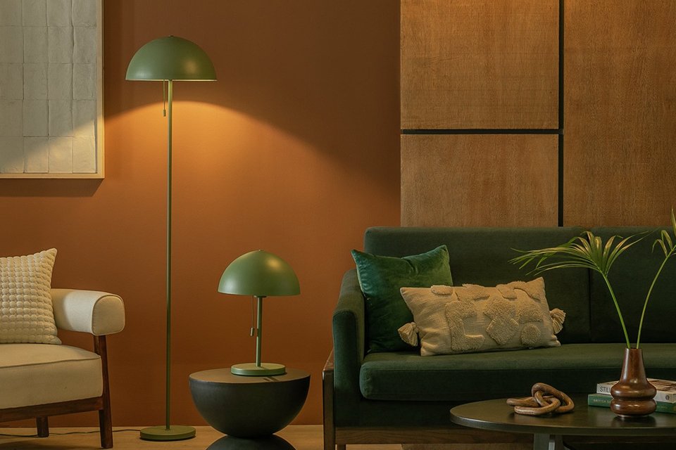 Habitat Steel Mushroom table and floor lamp in green colour placed next to a beige armchair and green sofa.