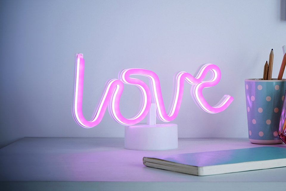 Glow Neon Love LED kids table lamp in white and pink on a white table.