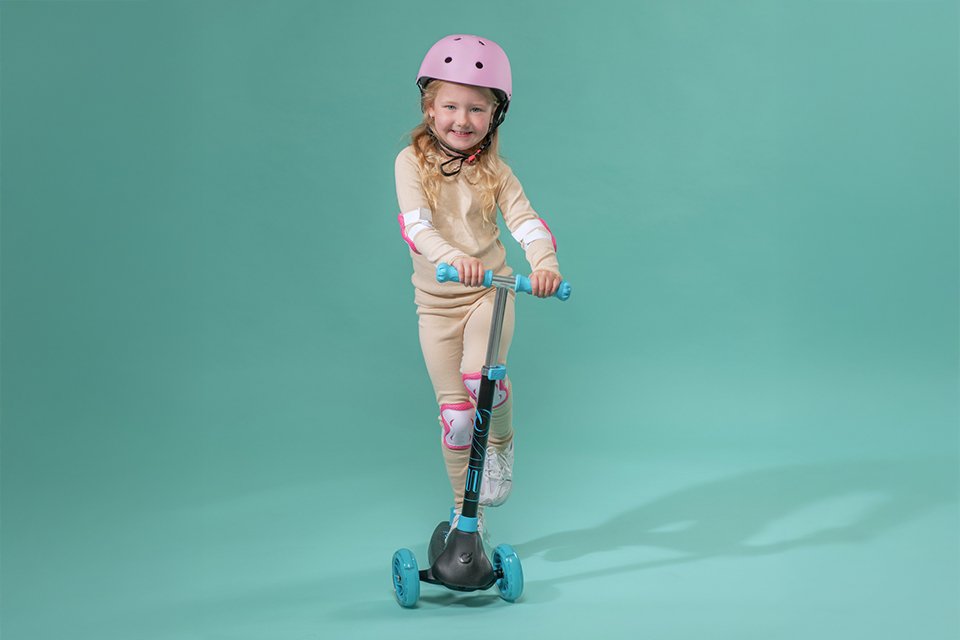 A kid on a blue Evo Eclipse Kids 3 Wheel Scooter. 