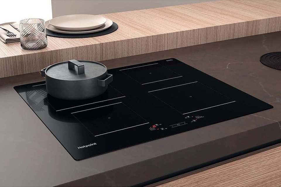 A grey pot on a Hotpoint TQ1460SNE Electric Induction Hob - Black.