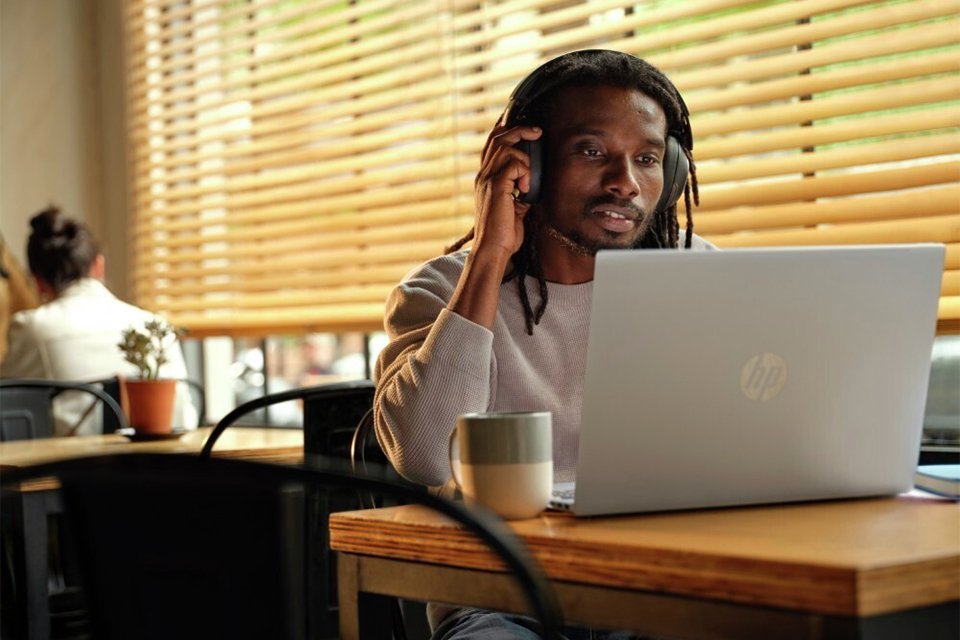 man using an HP laptop in a cafe