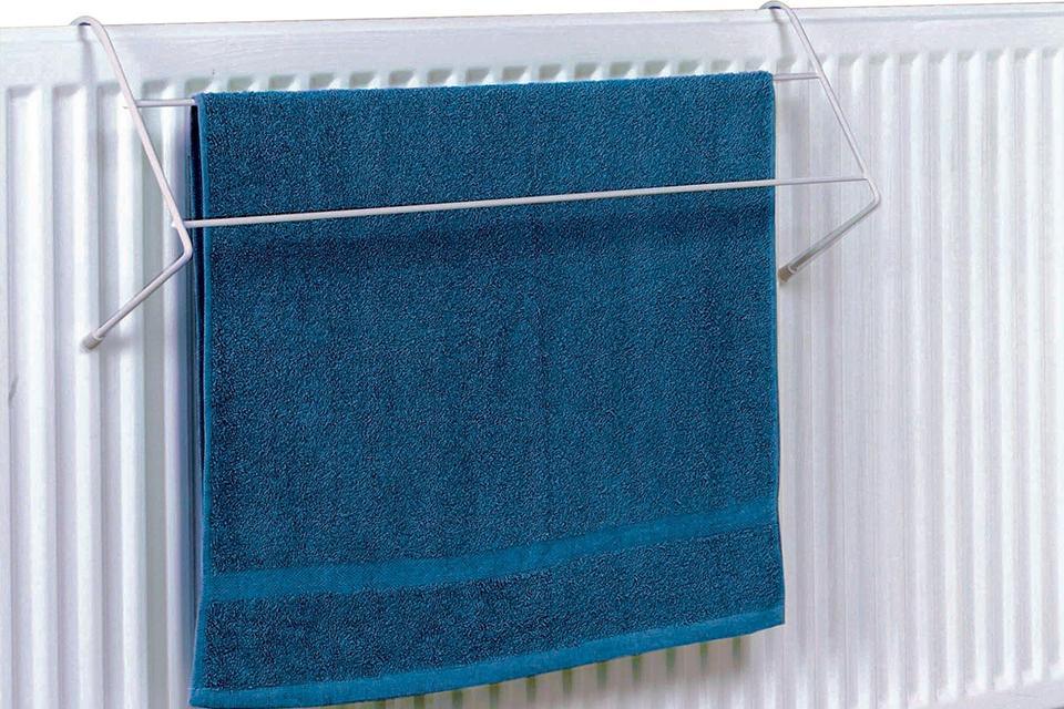 A blue towel drying on a white radiator airer.