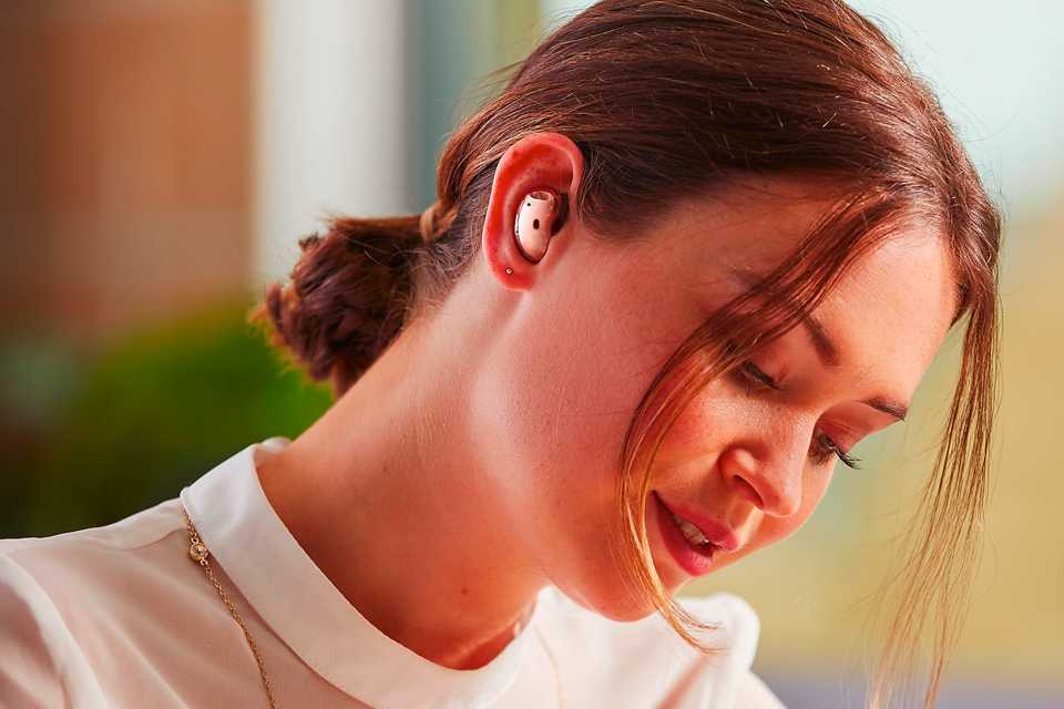 A woman immersed in her work while in her Samsung Galaxy Buds Live.