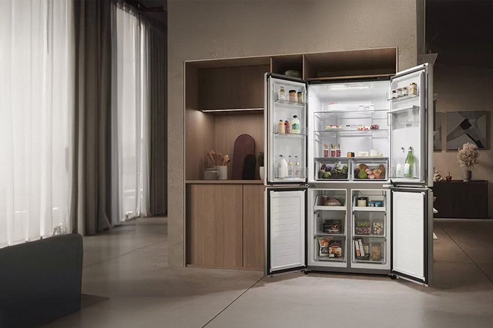 Quiet Mark certified Haier fridge freezer open with shelves stocked with food and drinks. 