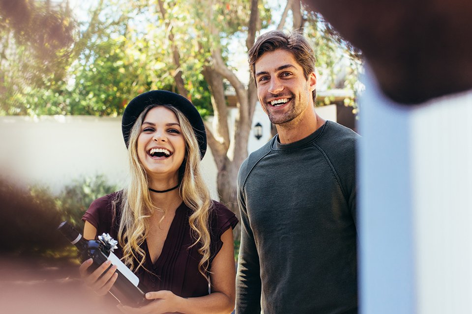 A couple being welcomed at the gate at a housewarming party.