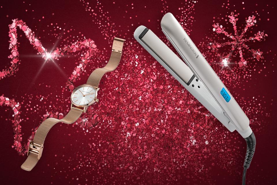 Some hair straighteners and a watch in front of a pink glittery background.