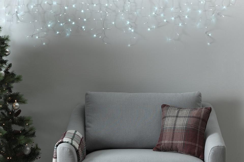 White icicle lights handing above an armchair.