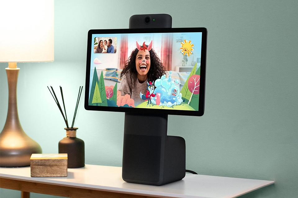 A Facebook Portal+ kept on a side table displaying a girl with colourful augmented reality filters.
