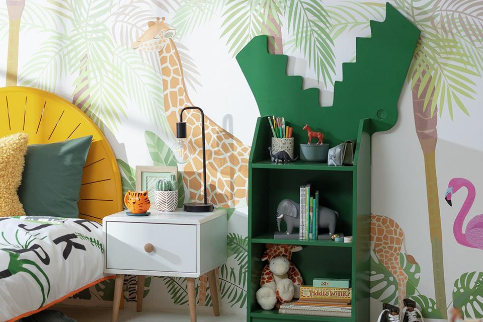 Image of kids' room with jungle wallpaper, a crocodile shaped shelf and yellow bed.