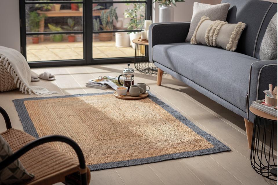 Image of a living room with a grey sofa and jute rug.
