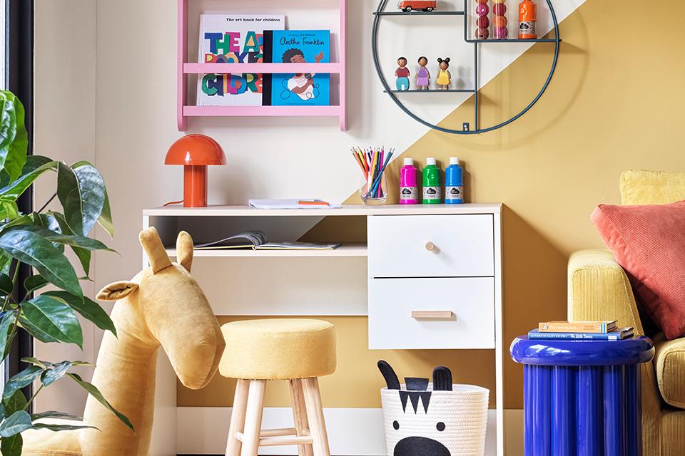 Image of a small, white kids' desk in a colourful bedroom.