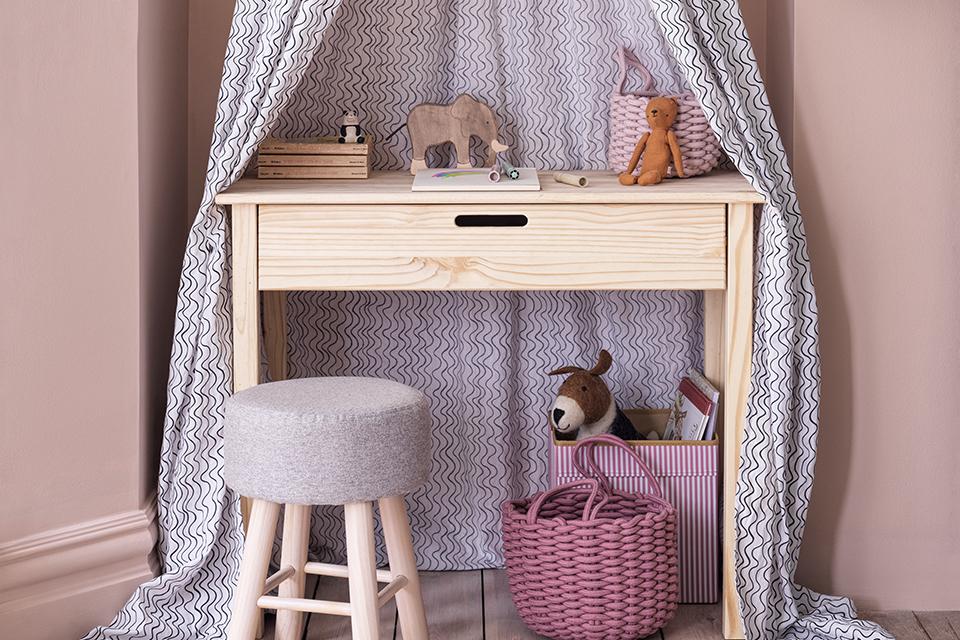An image of a small wooden desk with a mini canopy and grey stool.