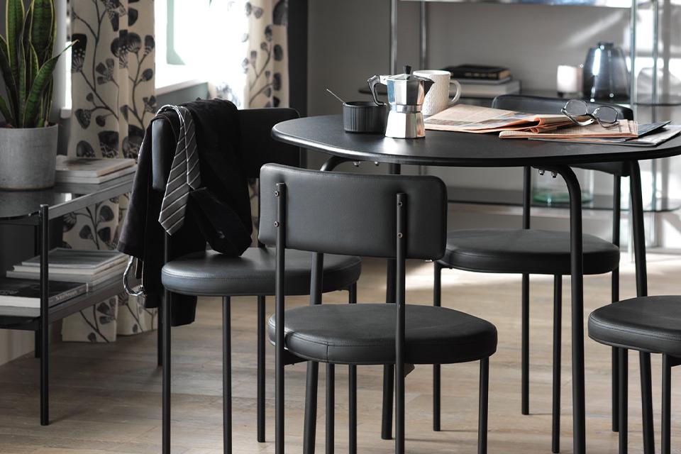 Compact black dining set in open plan living space.