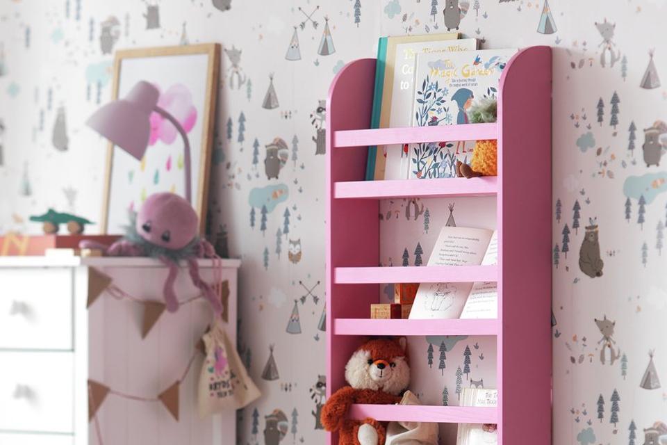 Pink shelving unit filled with toys and storybooks.