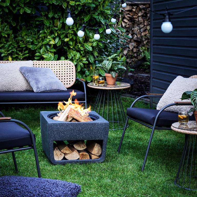 Image of a garden with a fire pitsurrounded by garden furniture.