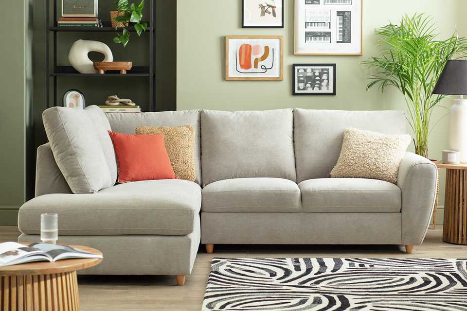 Grey corner sofa in a loving room with home accessories.
