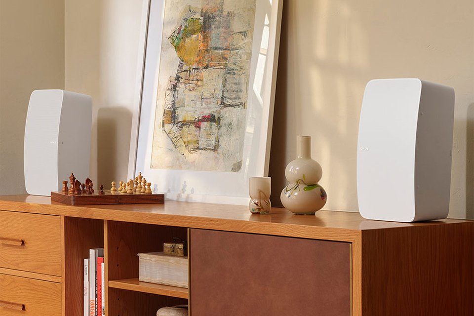 Two white Sonos subwoofers placed on a table.