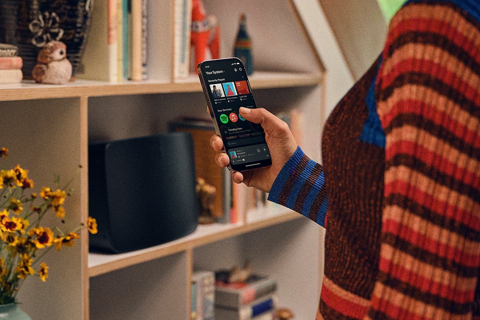 Someone holding a phone and browsing through a music app.