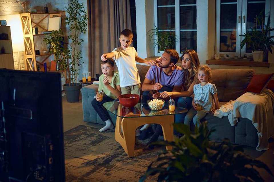 A family of five watching Harry Potter movie on their TV.