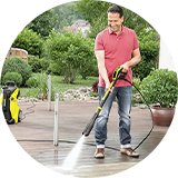 Man pressure washing garden patio.