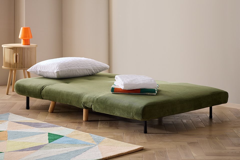 A Habitat fabric 2-seater small double sofa bed in green.