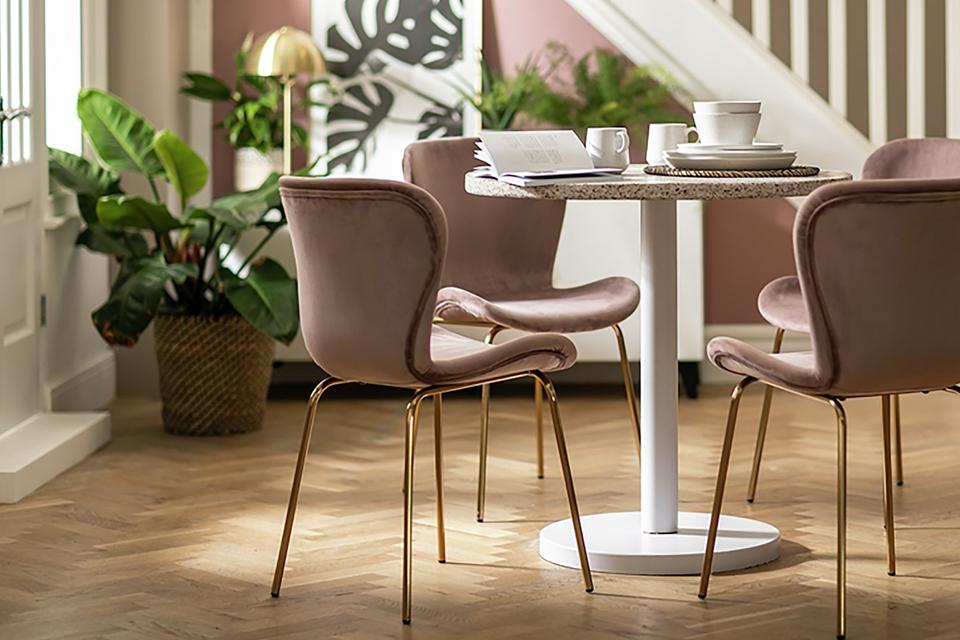 Image of small dining set with pink upholstered chairs.