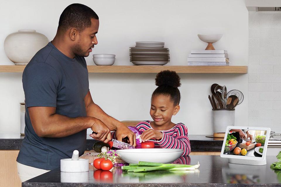 Image of a dad and child cooking using a tablet device.