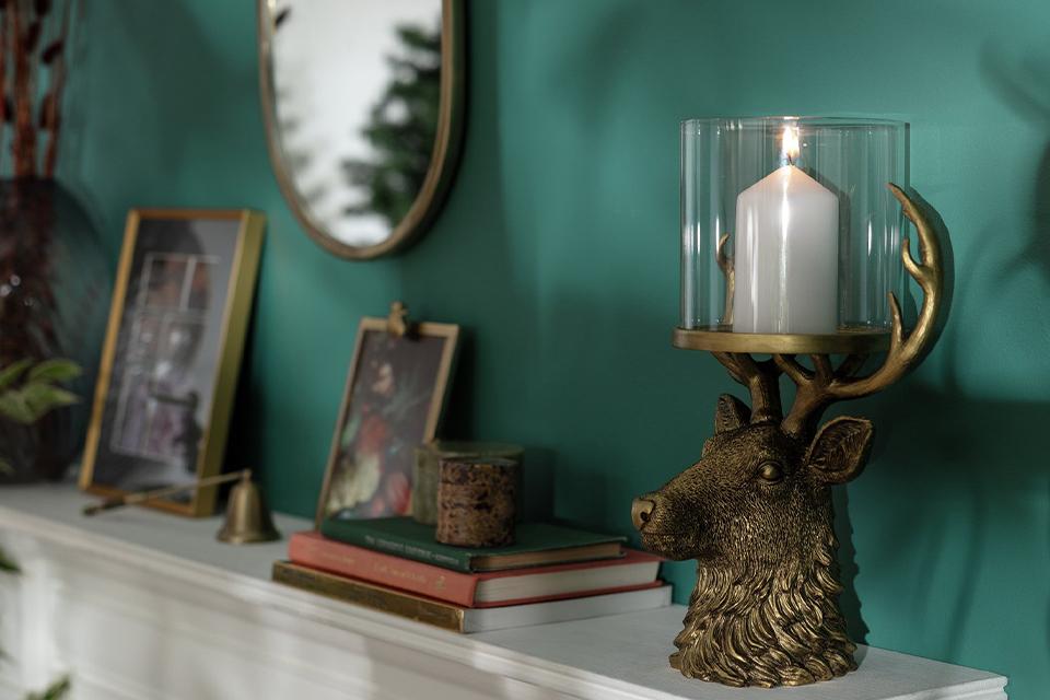 Image of a stags head candle holder on a mantlepiece.