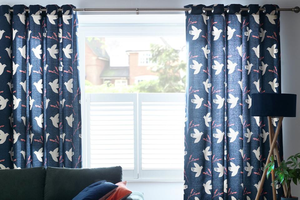 Image of blue curtains with a bird pattern.