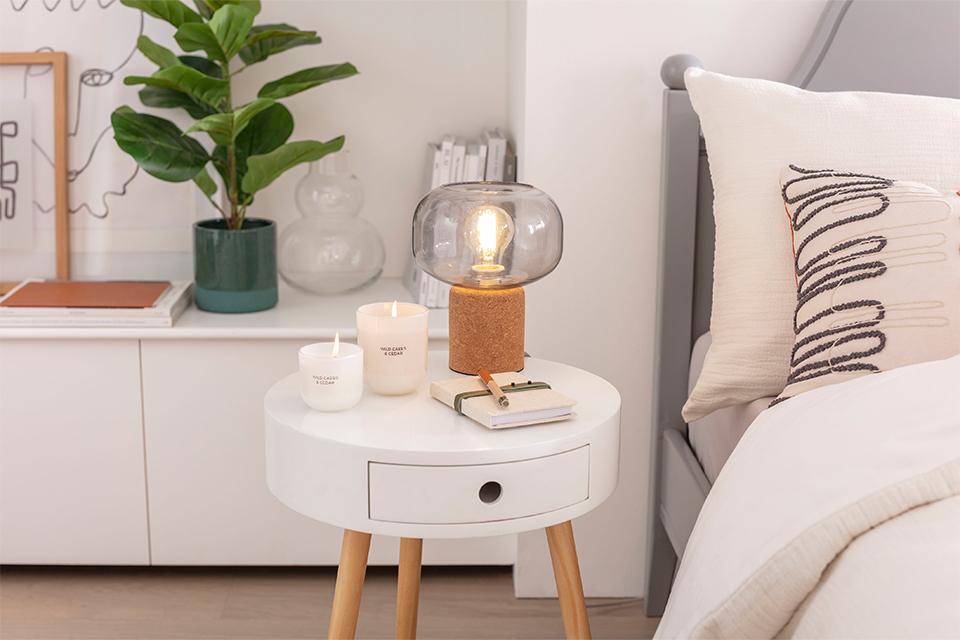 Table lamp with candles on bedside table.