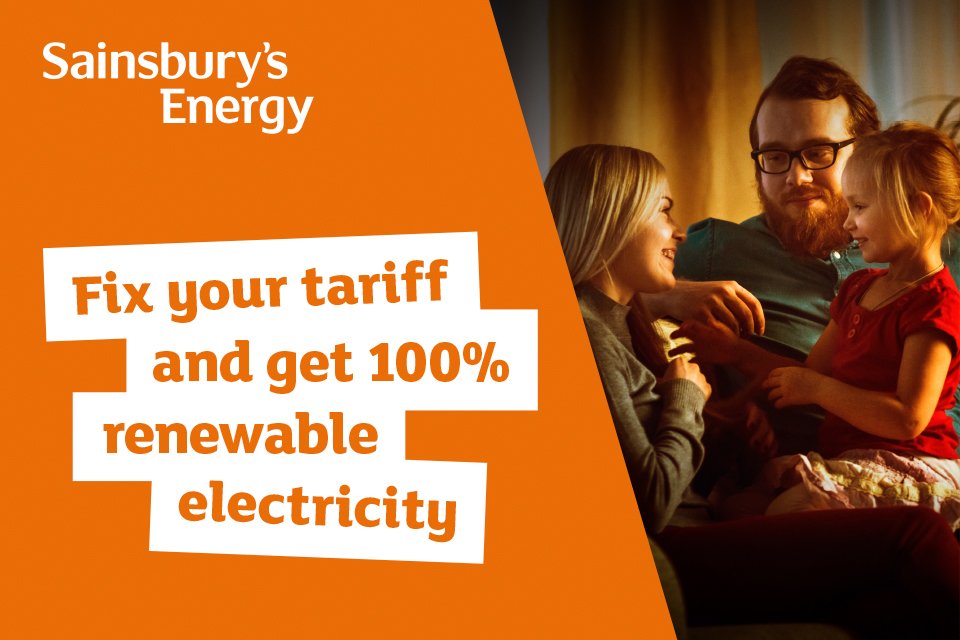 Dad and daughter stood on hill with wind turbine in the background. 