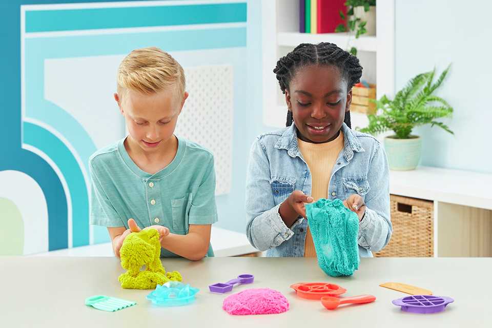 Friends playing with Kinetic Sand Ultimate Sandisfying Playset.