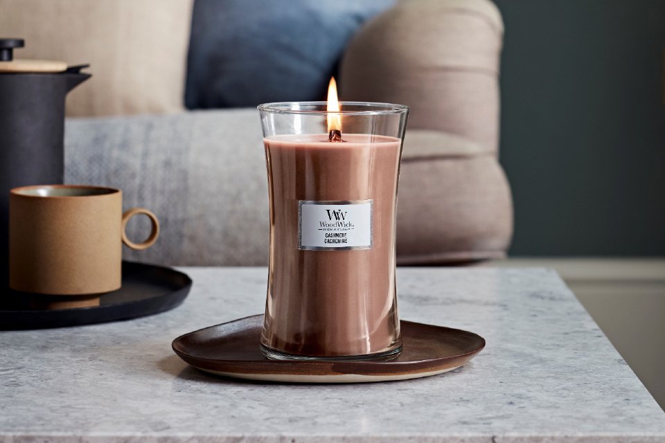 A Cashmere WoodWick® candle placed on a coffee table in a living room setup.