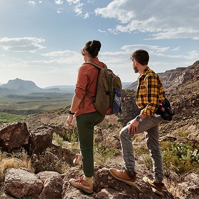 A man wearing a fitness tracker watching the view from a mountain.