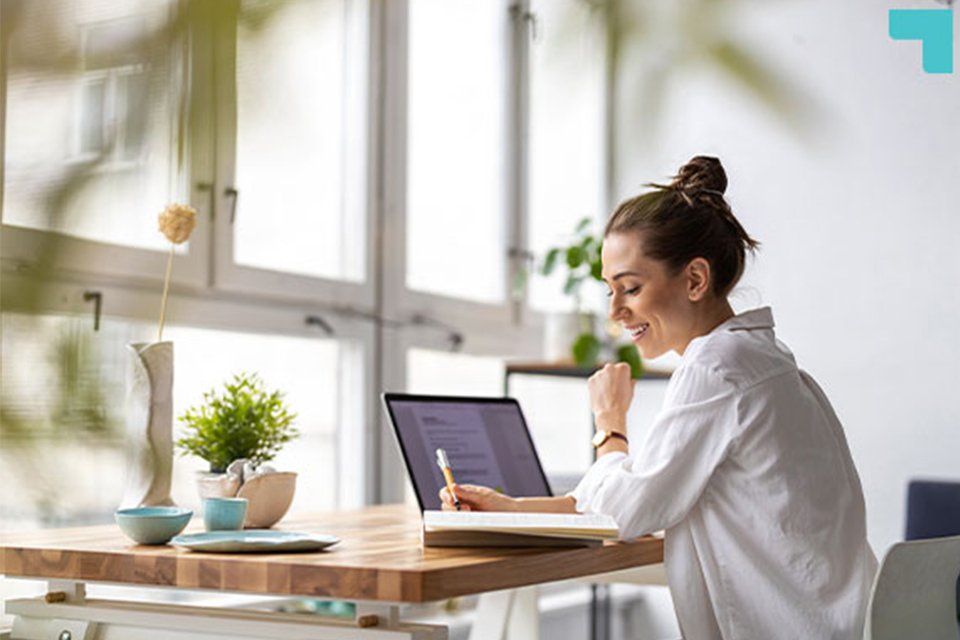 A woman working on her laptop in a home office setup. 