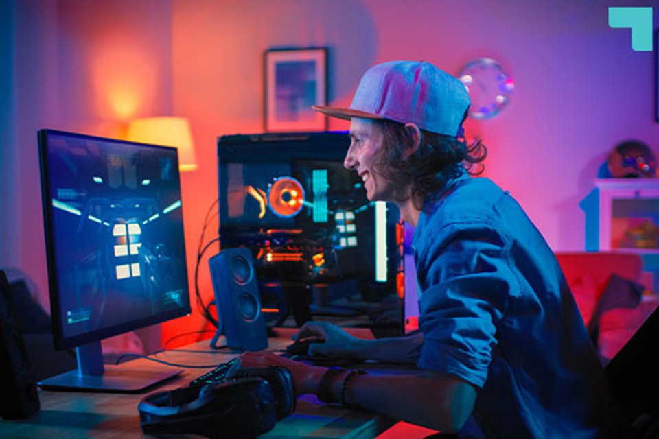 A man playing online games on a desktop in a gaming room setup.