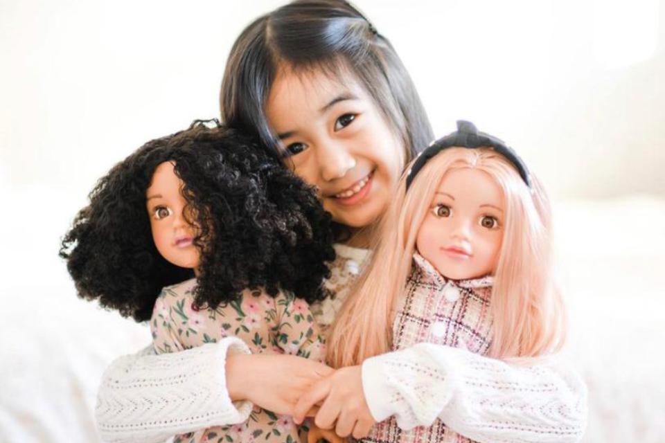 Little girl with two DesignaFriend dolls.