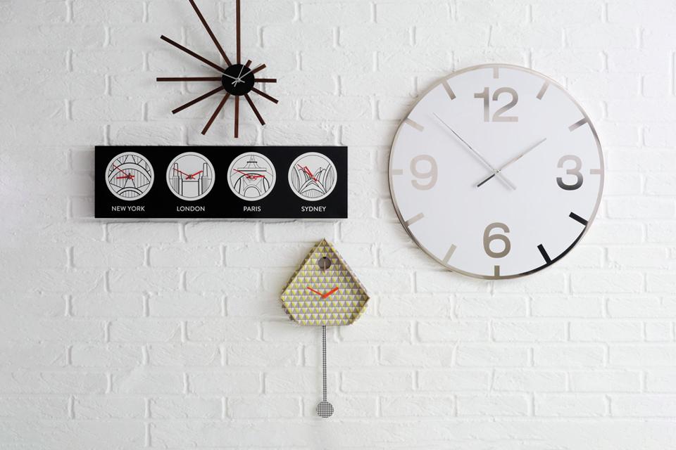 Image of a mustard coloured clock on a white wall.
